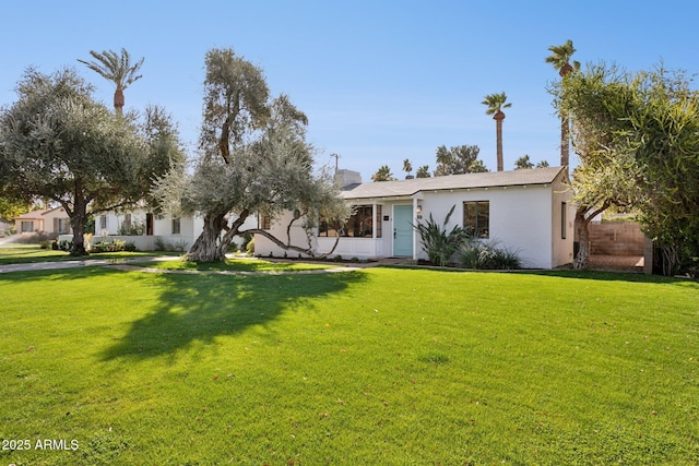 view of front of property featuring a front yard, fence, and stucco siding