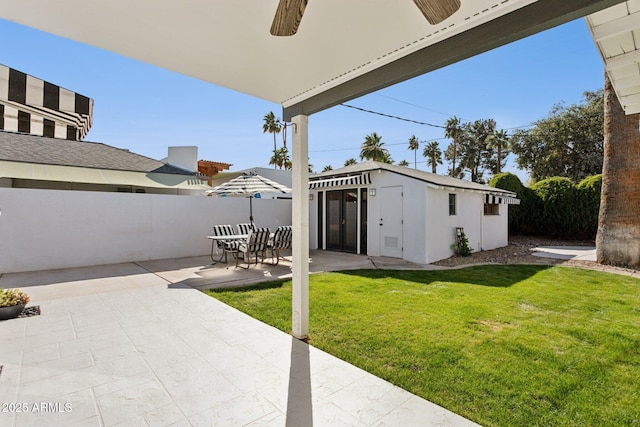 back of property featuring a patio area, a yard, an outdoor structure, and fence