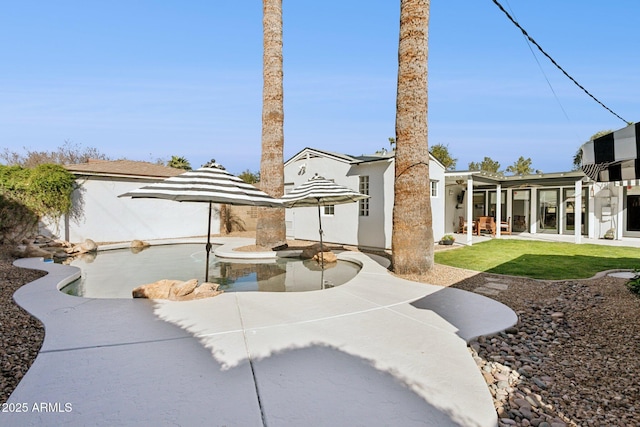 rear view of property featuring a patio and stucco siding