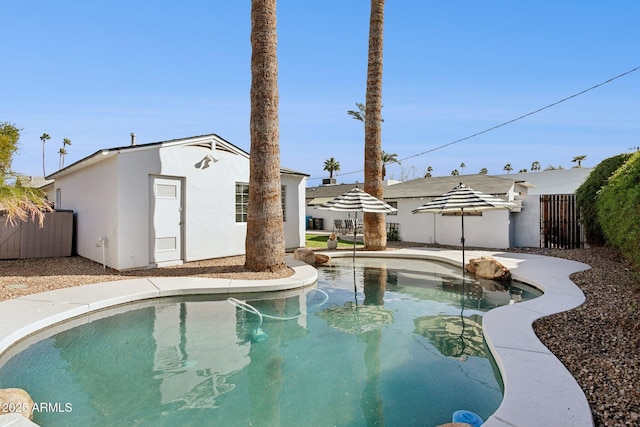 view of swimming pool featuring an outdoor structure, fence, and a fenced in pool