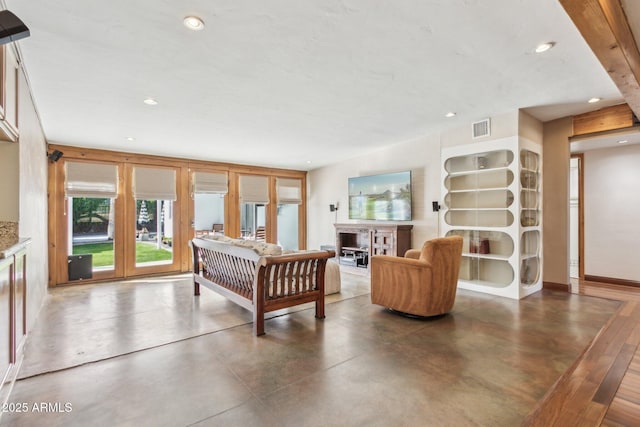 living area featuring recessed lighting, visible vents, a fireplace, and finished concrete flooring