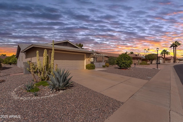 view of front of house featuring concrete driveway, an attached garage, and stucco siding