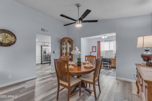 dining space featuring a ceiling fan, visible vents, light wood-style flooring, and baseboards