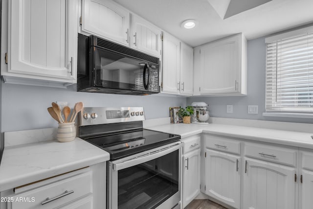 kitchen with black microwave, light stone countertops, stainless steel range with electric cooktop, white cabinetry, and recessed lighting