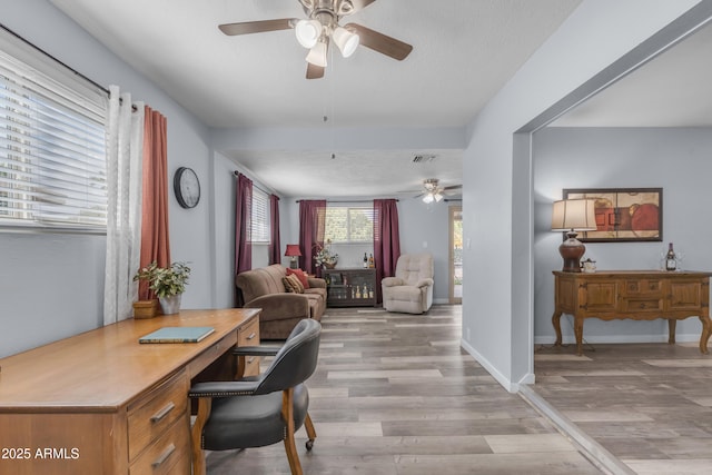 office space featuring light wood-type flooring, visible vents, ceiling fan, and baseboards