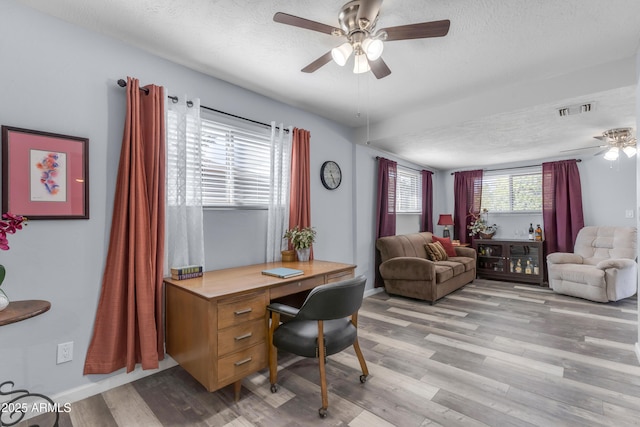 office area with a ceiling fan, visible vents, a textured ceiling, and light wood finished floors