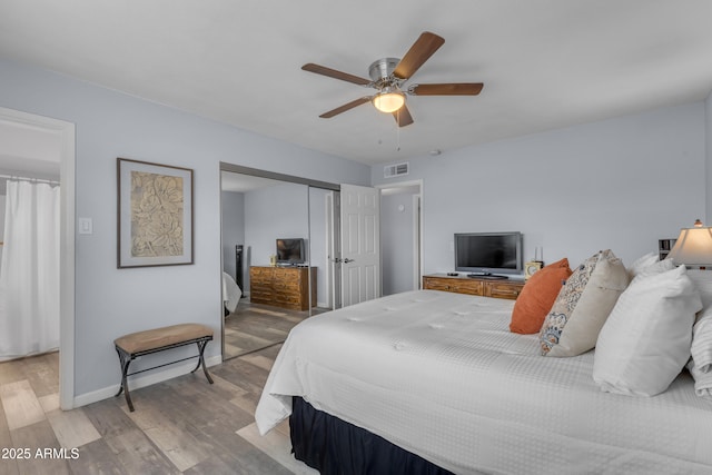 bedroom featuring light wood-style flooring, a ceiling fan, visible vents, baseboards, and a closet