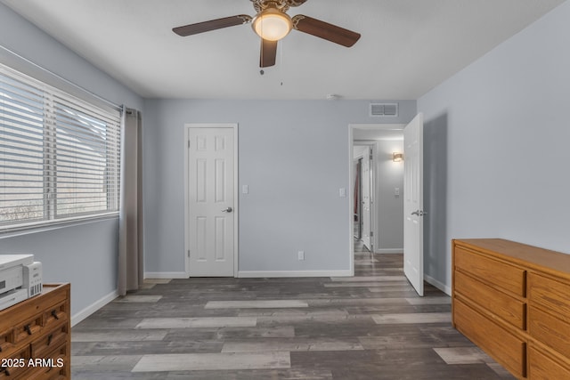 bedroom with dark wood-style floors, visible vents, ceiling fan, and baseboards