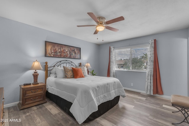 bedroom featuring ceiling fan, baseboards, and wood finished floors