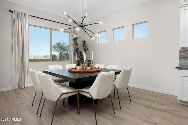 dining space with light hardwood / wood-style flooring and an inviting chandelier