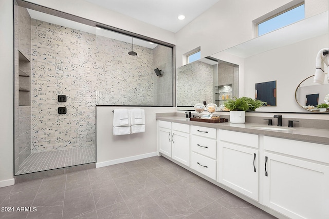 bathroom with a tile shower and vanity