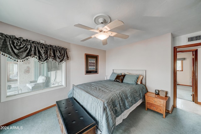 carpeted bedroom featuring multiple windows and ceiling fan