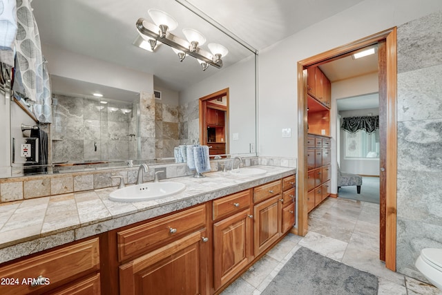 bathroom with a tile shower, vanity, and toilet