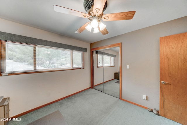 unfurnished bedroom featuring ceiling fan, a closet, and light carpet