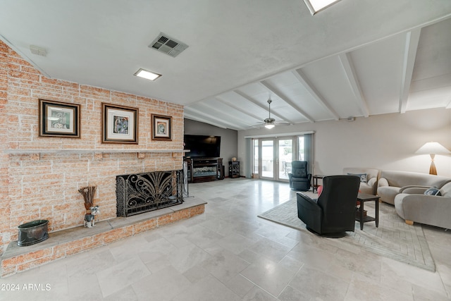 living room featuring french doors, lofted ceiling with beams, a brick fireplace, ceiling fan, and brick wall