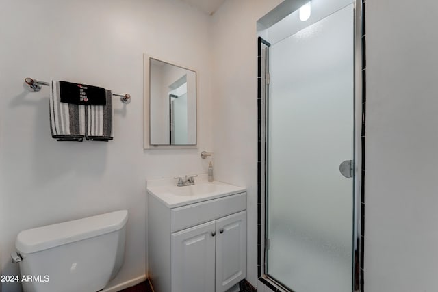 bathroom featuring vanity, toilet, and an enclosed shower