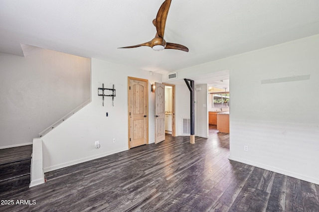 unfurnished living room featuring dark wood-style floors, baseboards, visible vents, and a ceiling fan