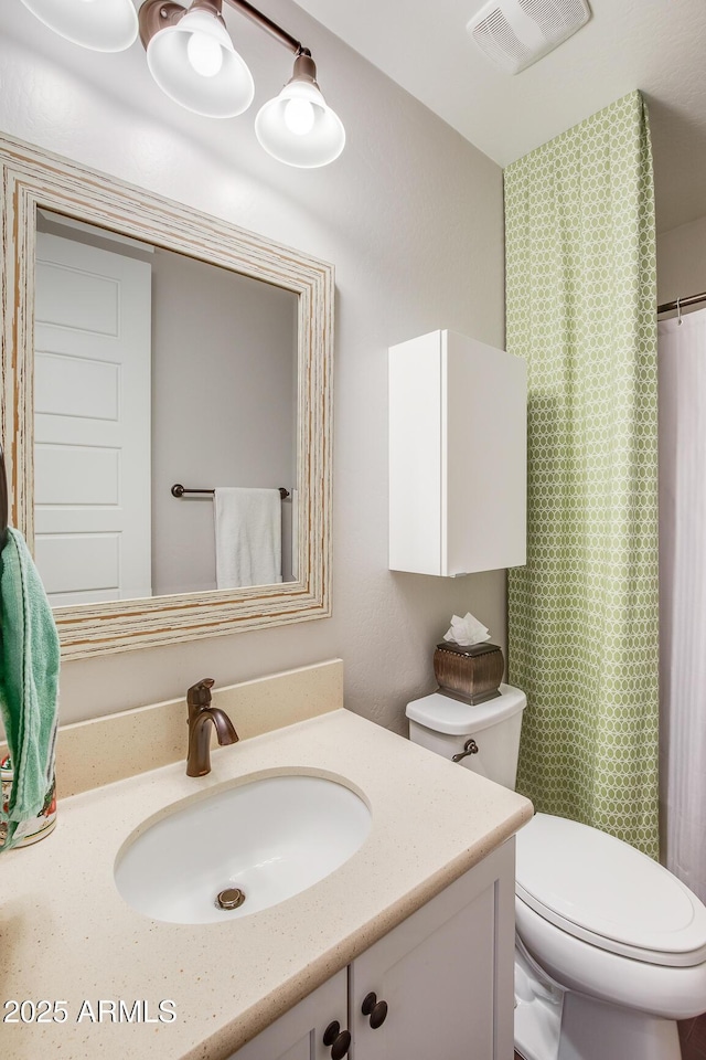 bathroom featuring toilet, a shower with shower curtain, vanity, and visible vents