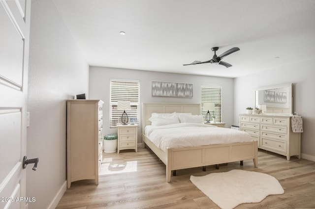 bedroom with light wood-style flooring, multiple windows, and baseboards