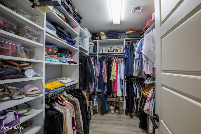 walk in closet featuring wood finished floors and visible vents