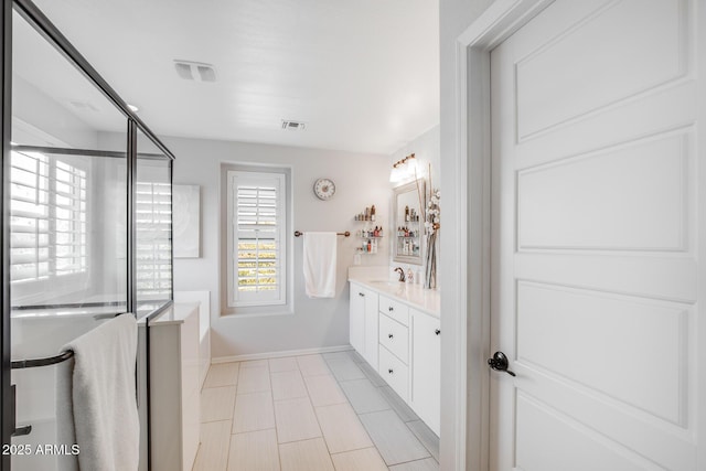 full bath with a stall shower, baseboards, visible vents, and vanity