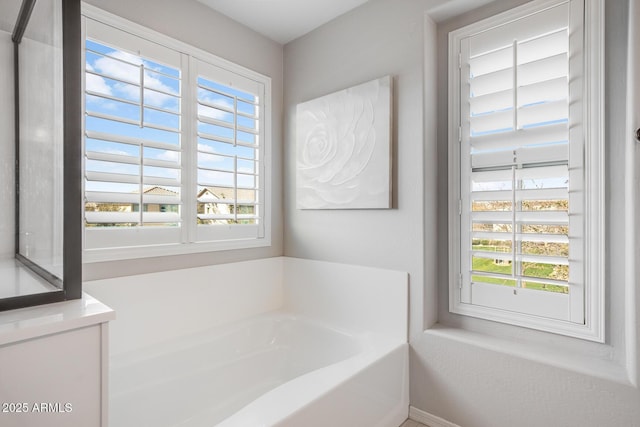 bathroom with plenty of natural light and a bath