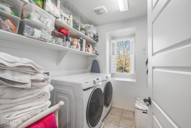 laundry room featuring light tile patterned floors, laundry area, visible vents, baseboards, and washer and clothes dryer