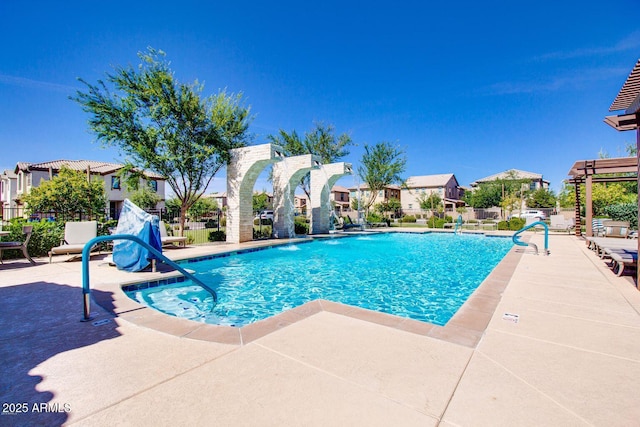 community pool with a residential view, a patio area, and fence