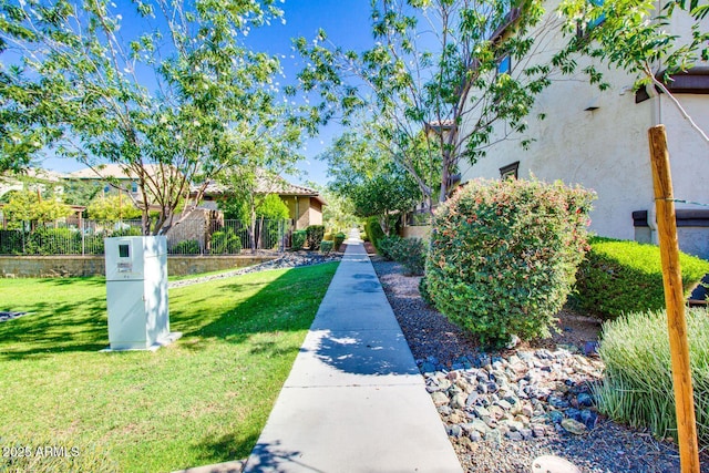 view of property's community with fence and a yard