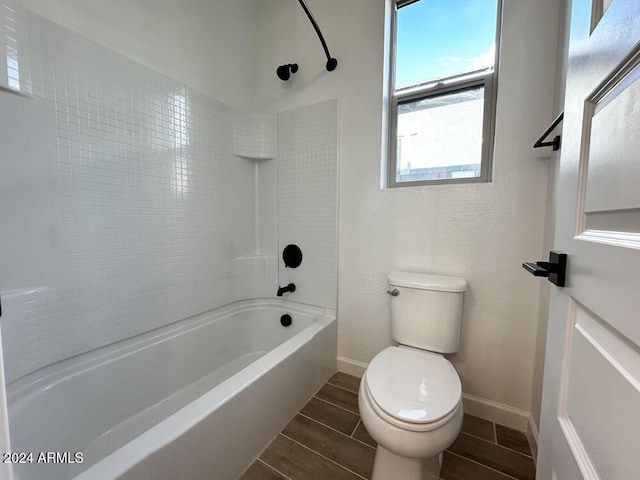 bathroom featuring toilet and tiled shower / bath combo