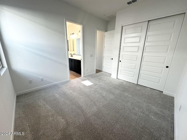 unfurnished bedroom with a closet, connected bathroom, and carpet