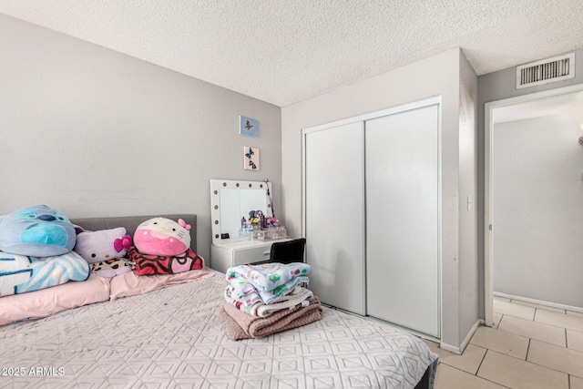 3646 N 67th Ave Unit 29, Phoenix, AZ 85033 - bedroom featuring light tile patterned flooring, a closet, and a textured ceiling