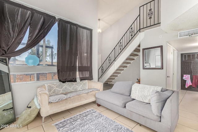 3646 N 67th Ave Unit 29, Phoenix, AZ 85033 - living room with tile patterned floors, stairs, and a towering ceiling