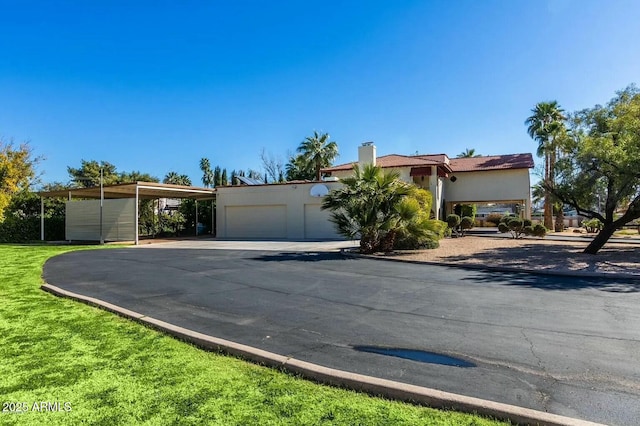 8426 N 15th Dr, Phoenix, AZ 85021 - view of front of home featuring driveway, a chimney, and stucco siding