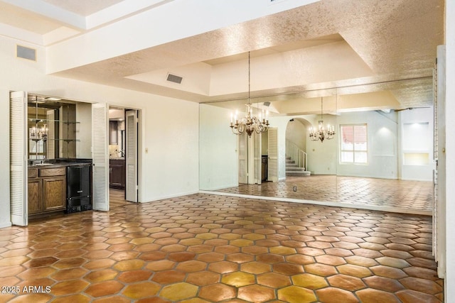 8426 N 15th Dr, Phoenix, AZ 85021 - unfurnished living room with arched walkways, baseboards, a notable chandelier, and visible vents
