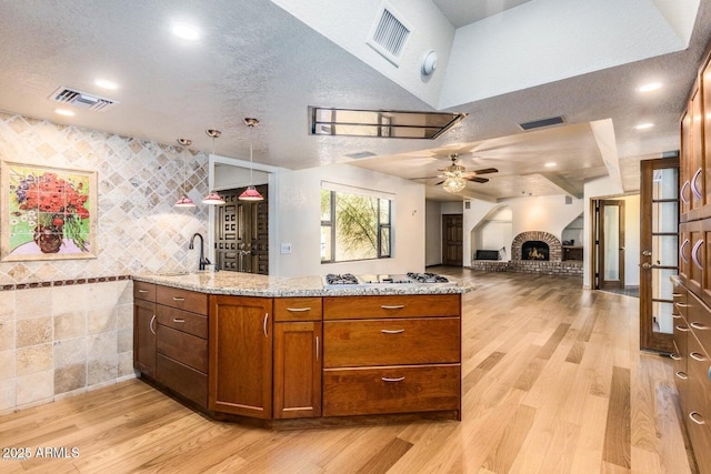 8426 N 15th Dr, Phoenix, AZ 85021 - kitchen with brown cabinets, visible vents, light wood finished floors, and ceiling fan