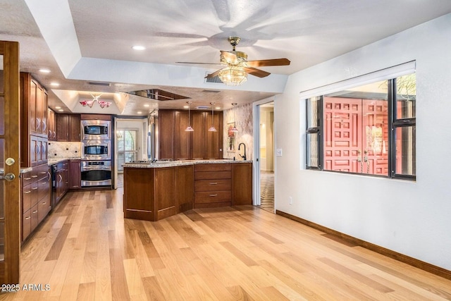 8426 N 15th Dr, Phoenix, AZ 85021 - kitchen featuring a peninsula, stainless steel microwave, light wood-type flooring, plenty of natural light, and a ceiling fan
