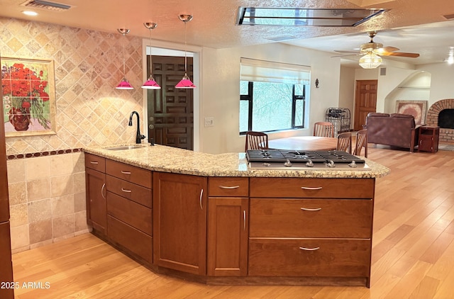 8426 N 15th Dr, Phoenix, AZ 85021 - kitchen featuring light stone counters, light wood-style floors, ceiling fan, and a sink