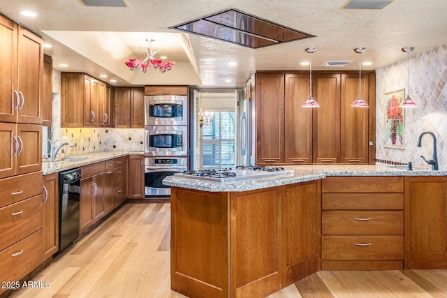 8426 N 15th Dr, Phoenix, AZ 85021 - kitchen with brown cabinets, light wood-type flooring, appliances with stainless steel finishes, and a sink