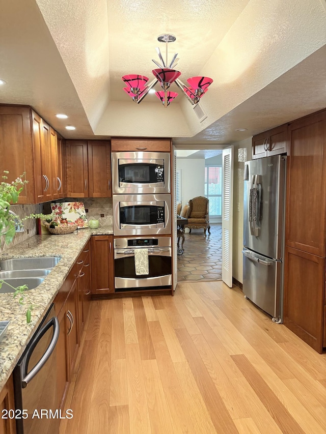8426 N 15th Dr, Phoenix, AZ 85021 - kitchen featuring light wood-type flooring, freestanding refrigerator, a tray ceiling, and dishwashing machine