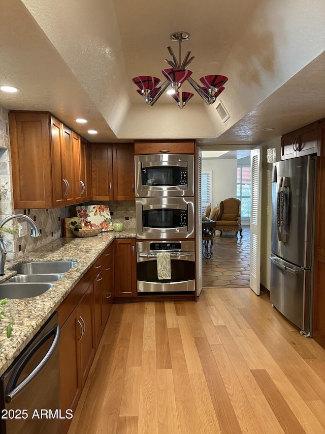 8426 N 15th Dr, Phoenix, AZ 85021 - kitchen featuring tasteful backsplash, stainless steel appliances, light wood finished floors, and a sink