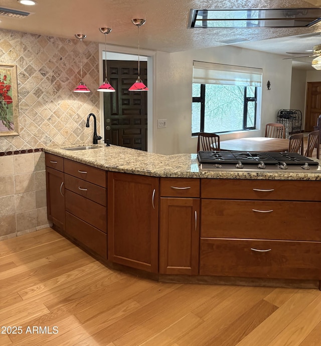 8426 N 15th Dr, Phoenix, AZ 85021 - kitchen featuring a sink, visible vents, light wood-style floors, stainless steel gas stovetop, and light stone counters
