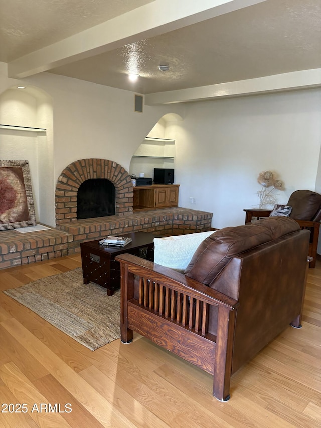 8426 N 15th Dr, Phoenix, AZ 85021 - living room with wood finished floors, a brick fireplace, and visible vents