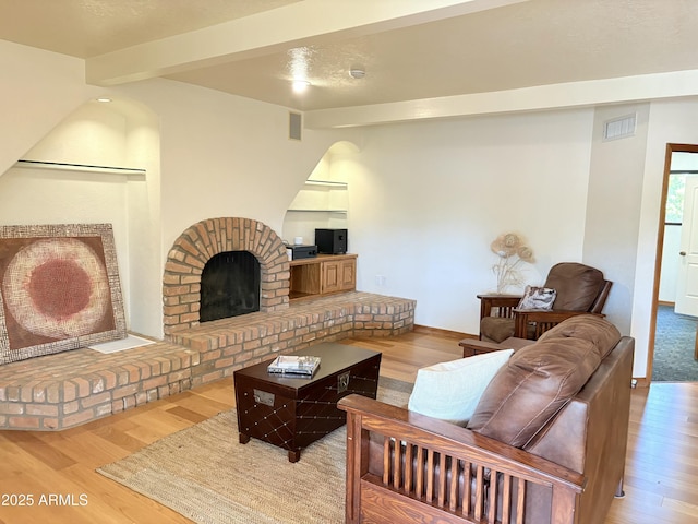 8426 N 15th Dr, Phoenix, AZ 85021 - living room with beamed ceiling, a brick fireplace, wood finished floors, and visible vents