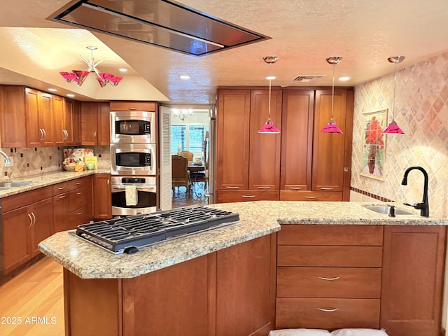 8426 N 15th Dr, Phoenix, AZ 85021 - kitchen with brown cabinetry, decorative backsplash, stainless steel appliances, and a sink