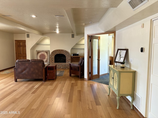 8426 N 15th Dr, Phoenix, AZ 85021 - living area featuring a brick fireplace, visible vents, and light wood finished floors