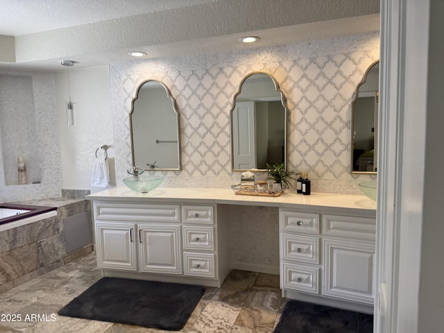 8426 N 15th Dr, Phoenix, AZ 85021 - bathroom with a textured ceiling, double vanity, a garden tub, and a sink