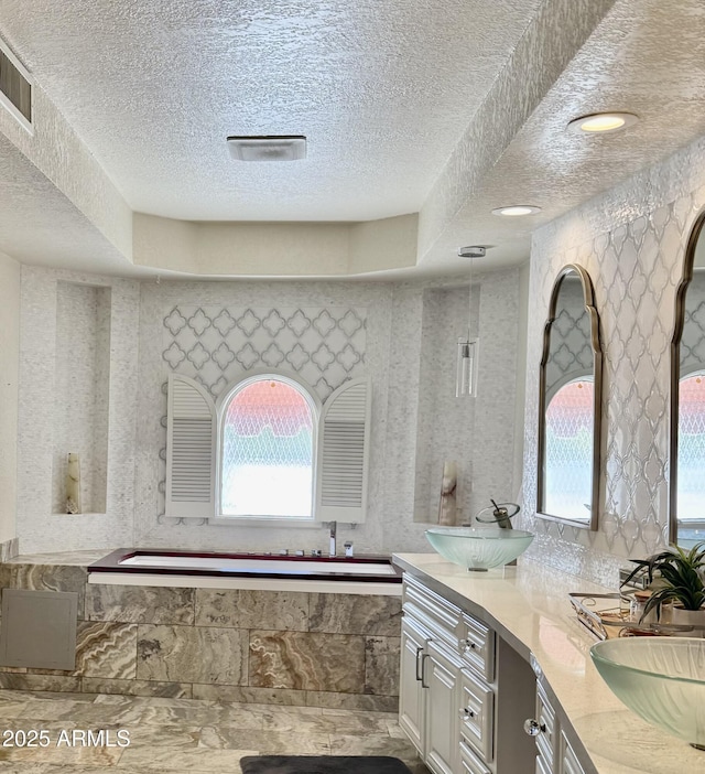 8426 N 15th Dr, Phoenix, AZ 85021 - bathroom with a sink, a textured ceiling, double vanity, visible vents, and a garden tub