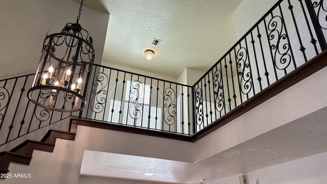 8426 N 15th Dr, Phoenix, AZ 85021 - stairs featuring an inviting chandelier, a textured ceiling, and visible vents