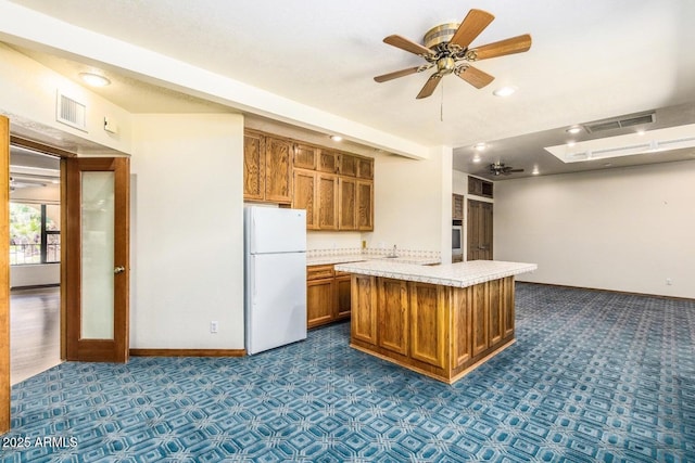 8426 N 15th Dr, Phoenix, AZ 85021 - kitchen featuring brown cabinets, light countertops, freestanding refrigerator, baseboards, and ceiling fan